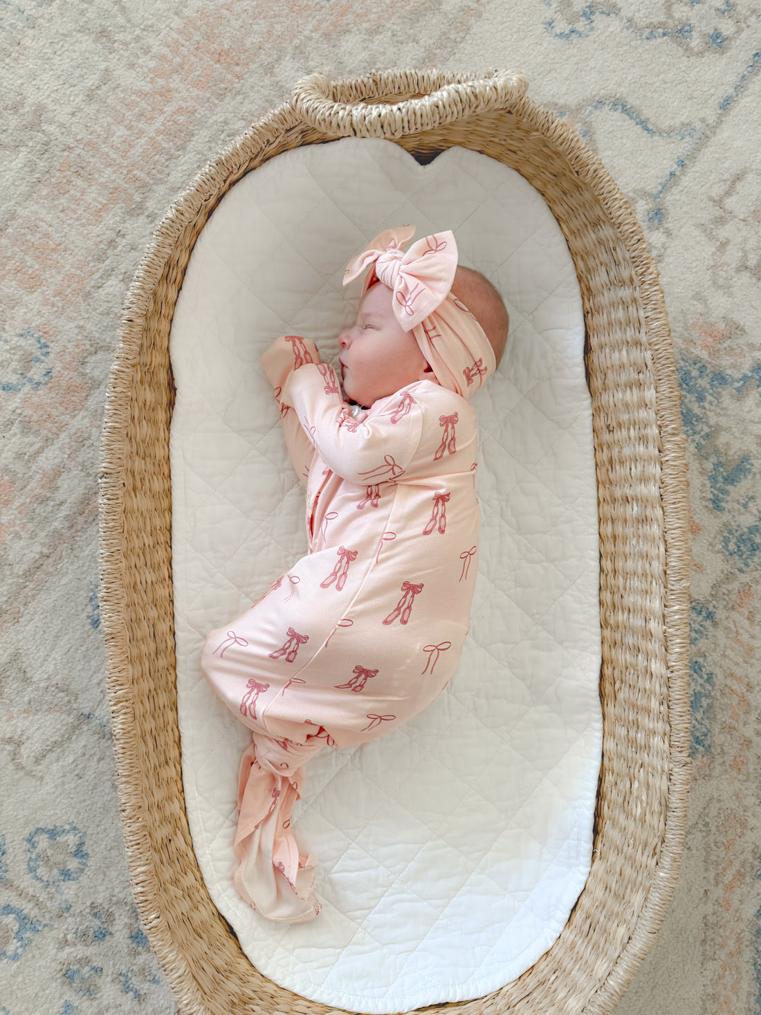 Newborn baby in pink ballet bamboo knotted gown
