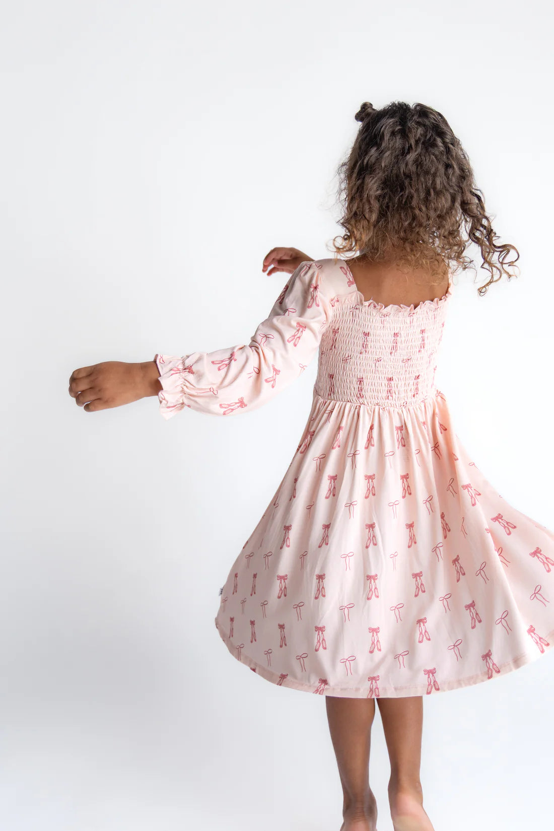 Girl wearing pink ballet print twirl dress