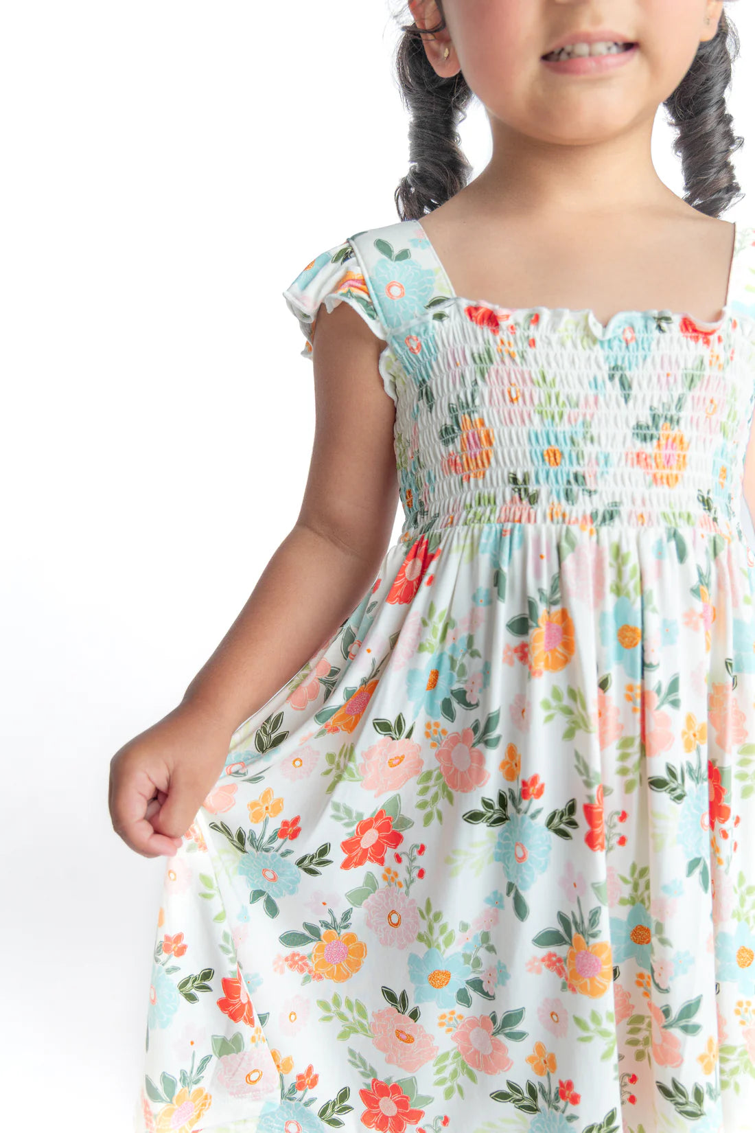 Child wearing a floral bamboo twirl dress on a white background