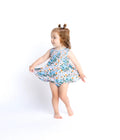 Child wearing a floral twirl dress on a white background