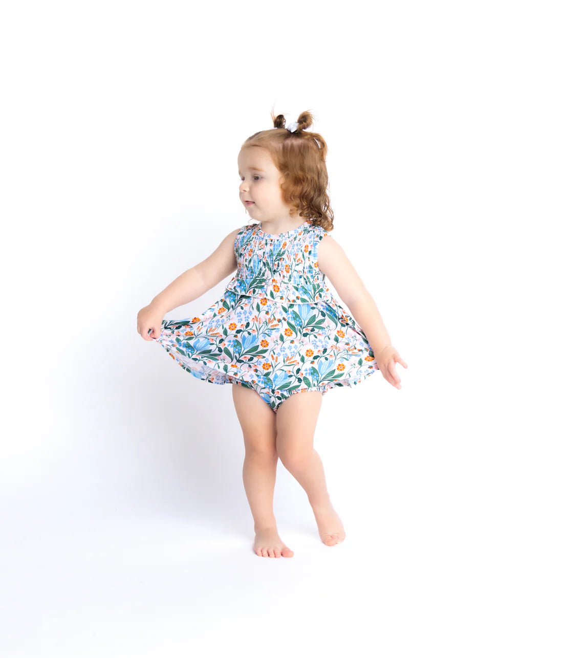 Child wearing a floral twirl dress on a white background